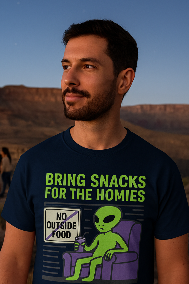 Man wearing a t-shirt with an alien graphic and text in a desert setting