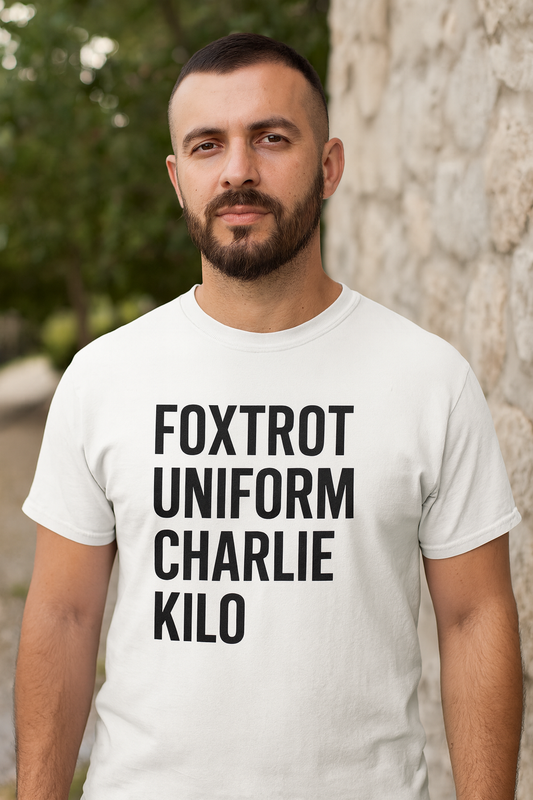 Man wearing a white t-shirt with 'FOXTROT UNIFORM CHARLIE KILO' text outdoors.