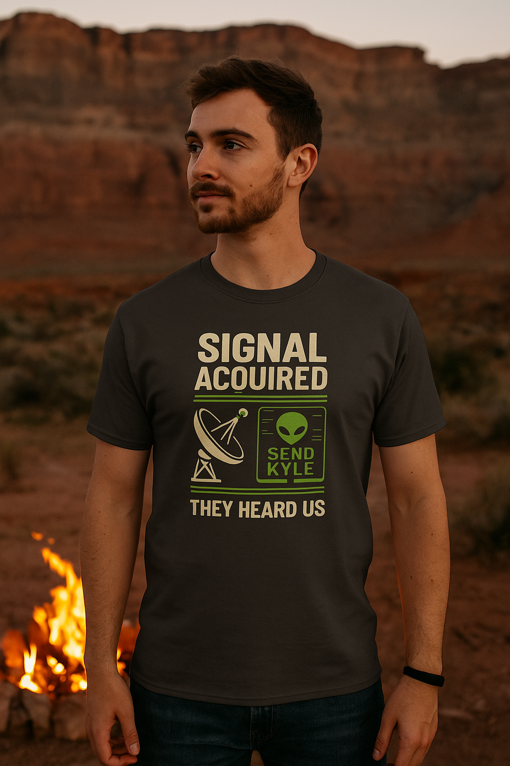 Man wearing a t-shirt with text and graphics in a desert setting with a campfire.
