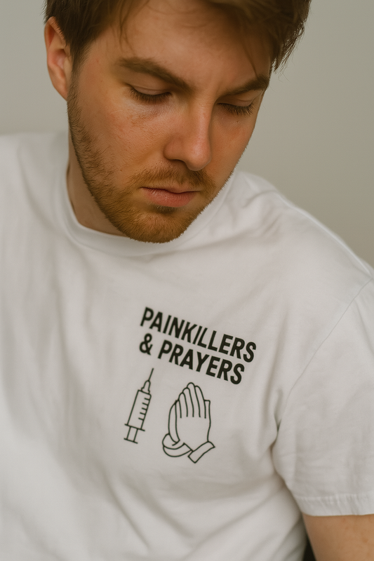 Man wearing a white t-shirt with 'Painkillers & Prayers' text and graphics. escape from tarkov inspired