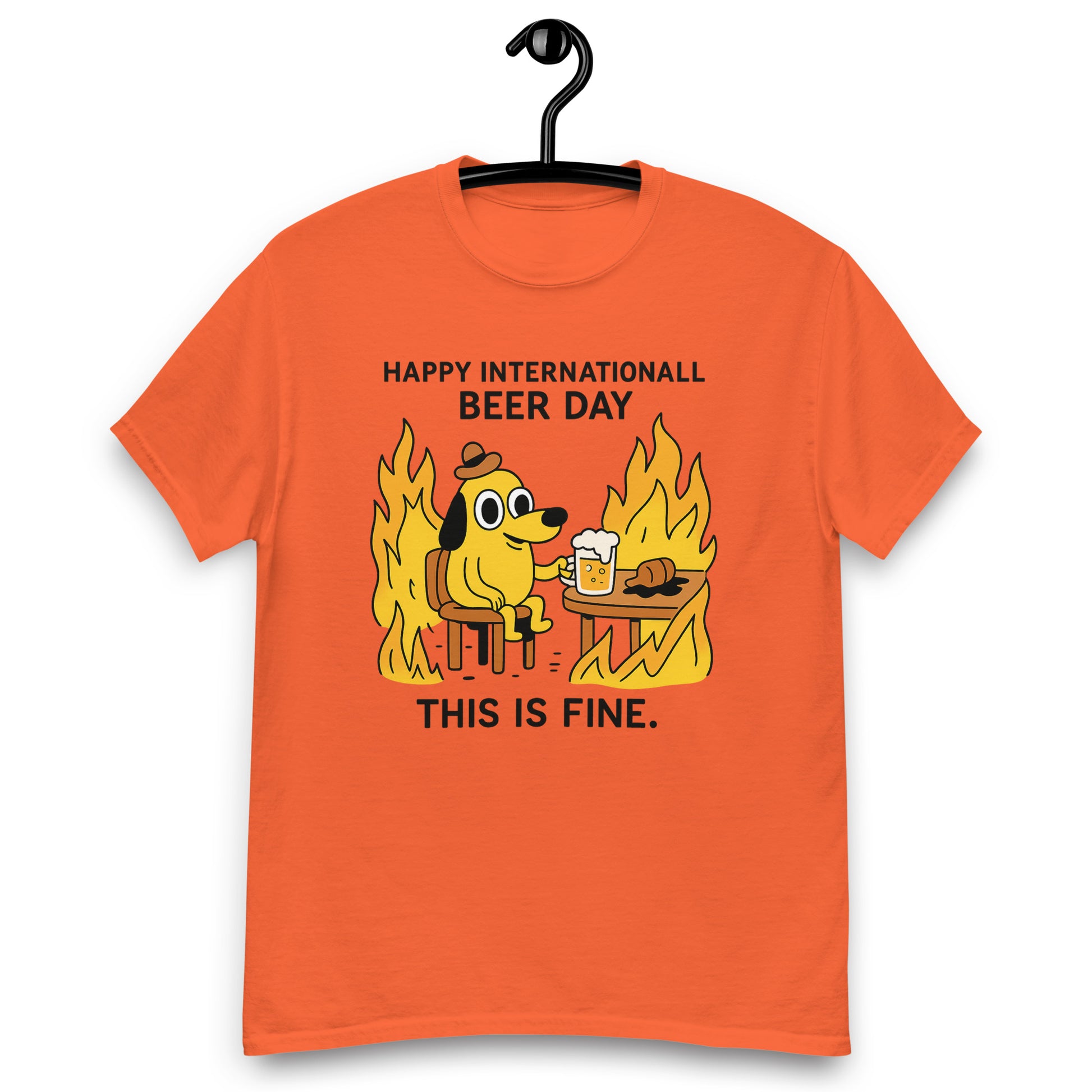 Graphic t-shirt with beer mugs clinking and International Beer Day text, flat lay