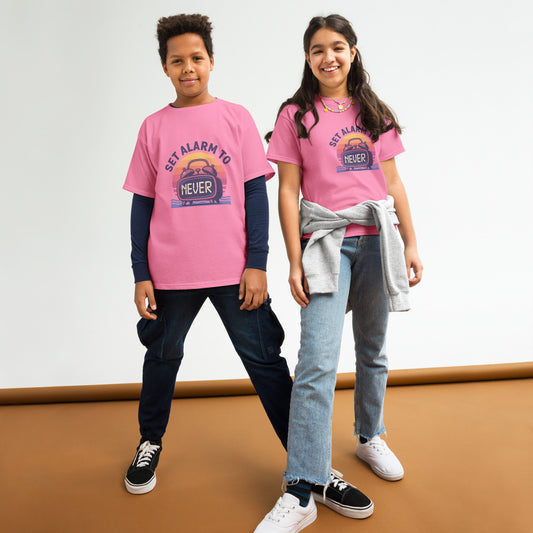School’s Out t-shirt with bold colorful lettering, flat lay on wooden surface